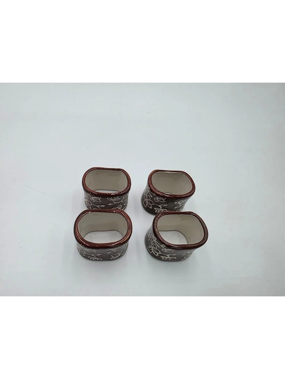 Set of 4 Brown Ceramic Napkin Rings with White Floral Design
